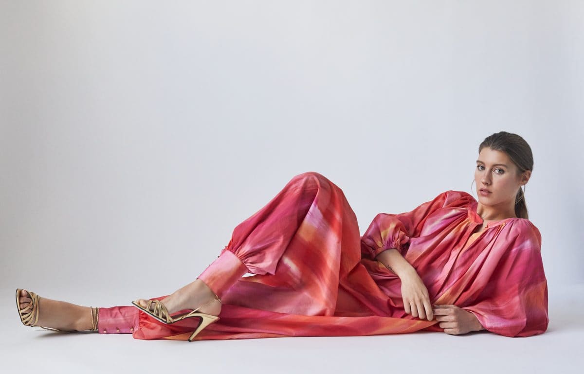 Woman lying down wearing a pink jumpsuit