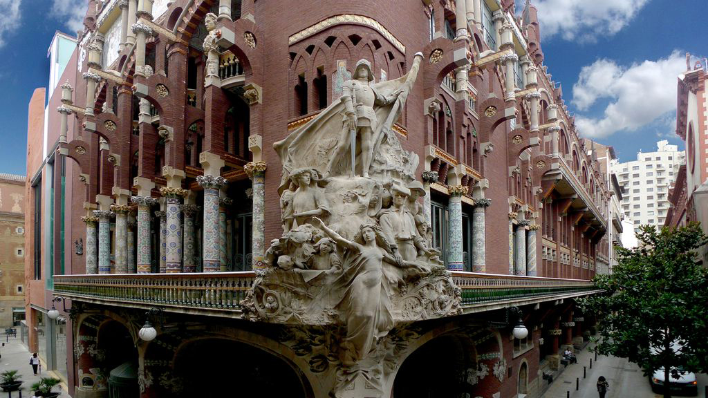 A large building featuring a prominent statue atop its roof