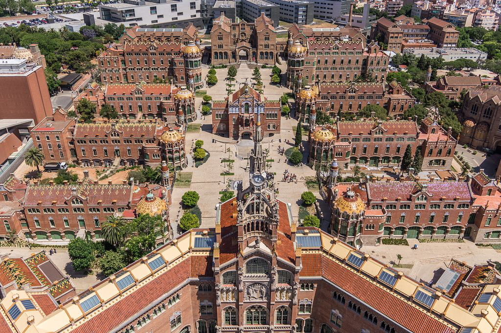 Aerial view showcasing a large building surrounded by multiple smaller structures in an urban landscape