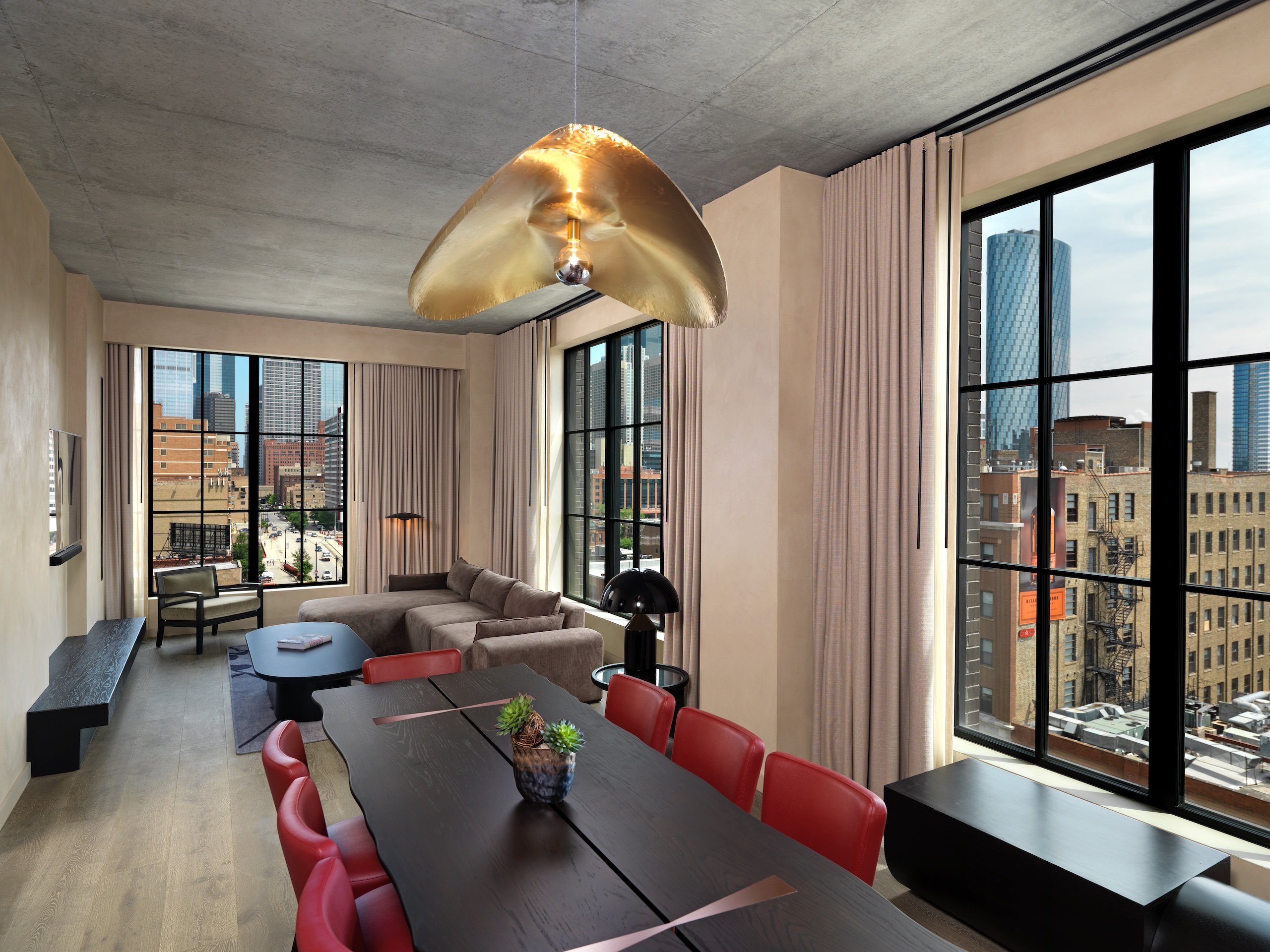 dining room with long table and red chairs and gold light fixture
