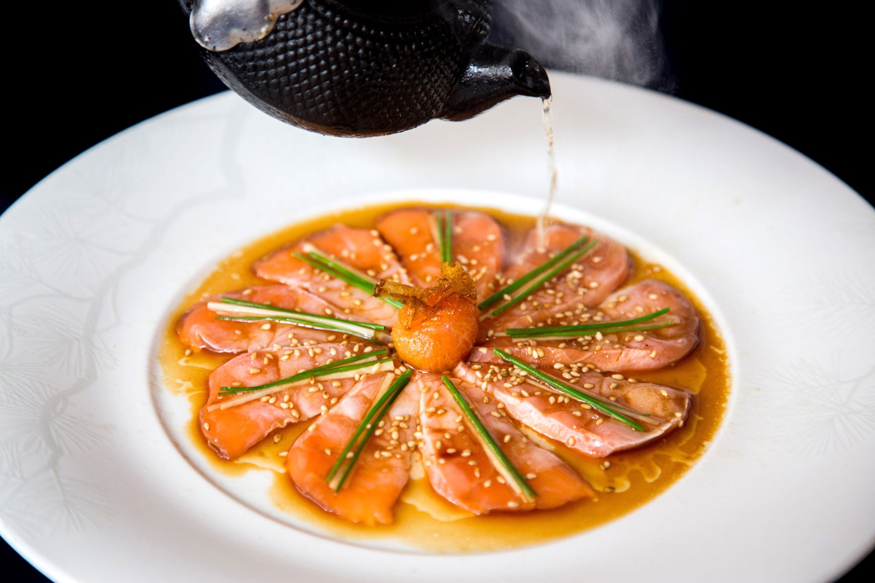 a kettle pouring hot liquid over food