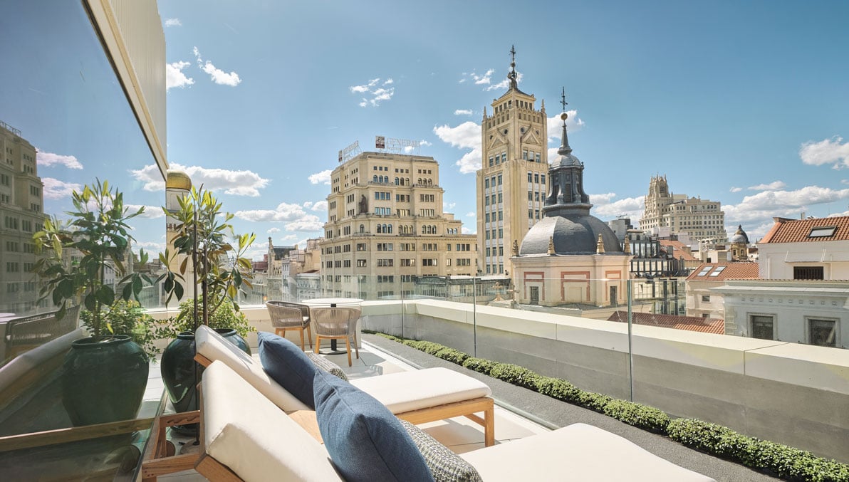 a balcony with lounge chairs overlooking the city