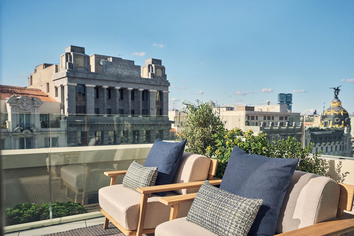 two chairs on a balcony overlooking the city in the hikari suite