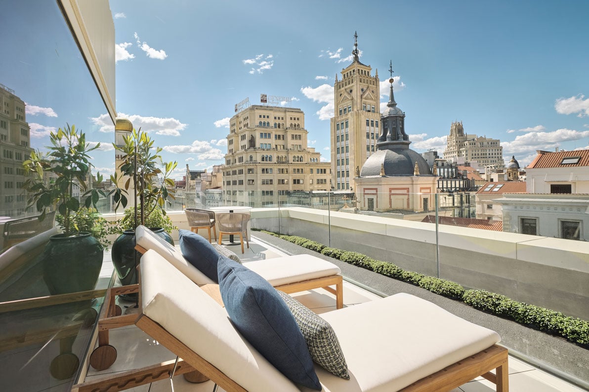 two lounge chairs on the balcony of yuhi suite with a view of the city