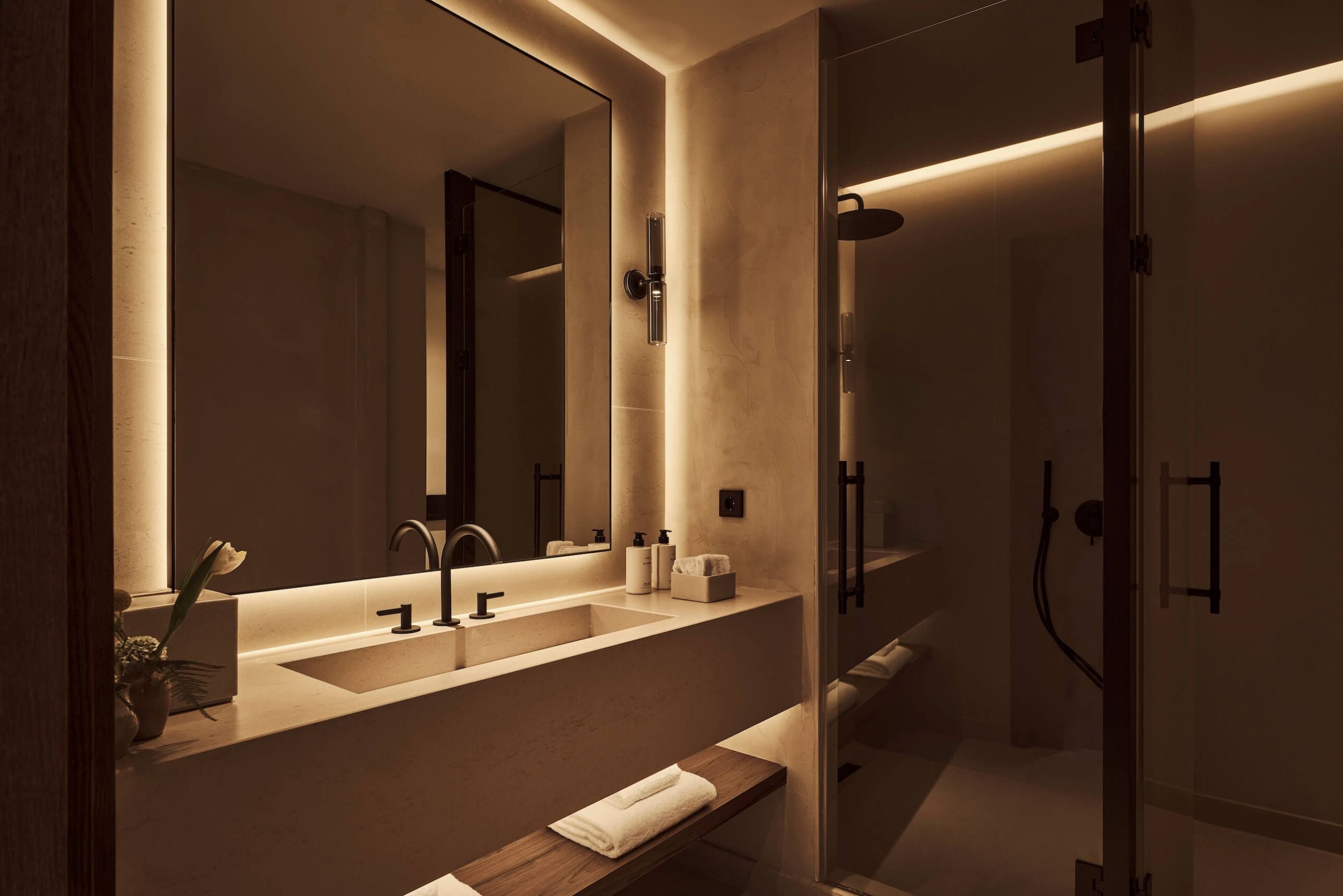 the shower, bathroom sink and mirror in the deluxe room