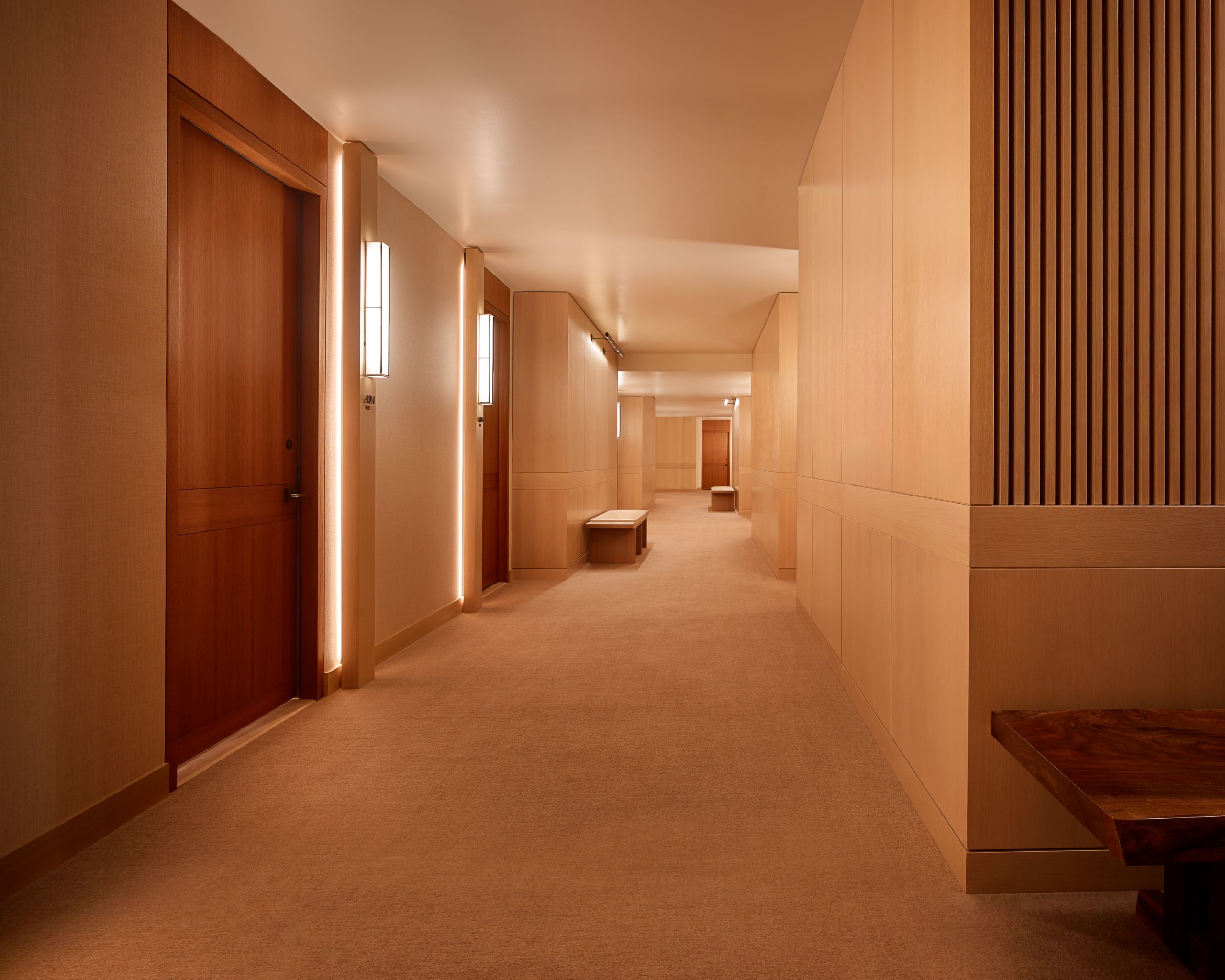 Nobu hallway showing a few bench seating areas and hallway lit up with lights.