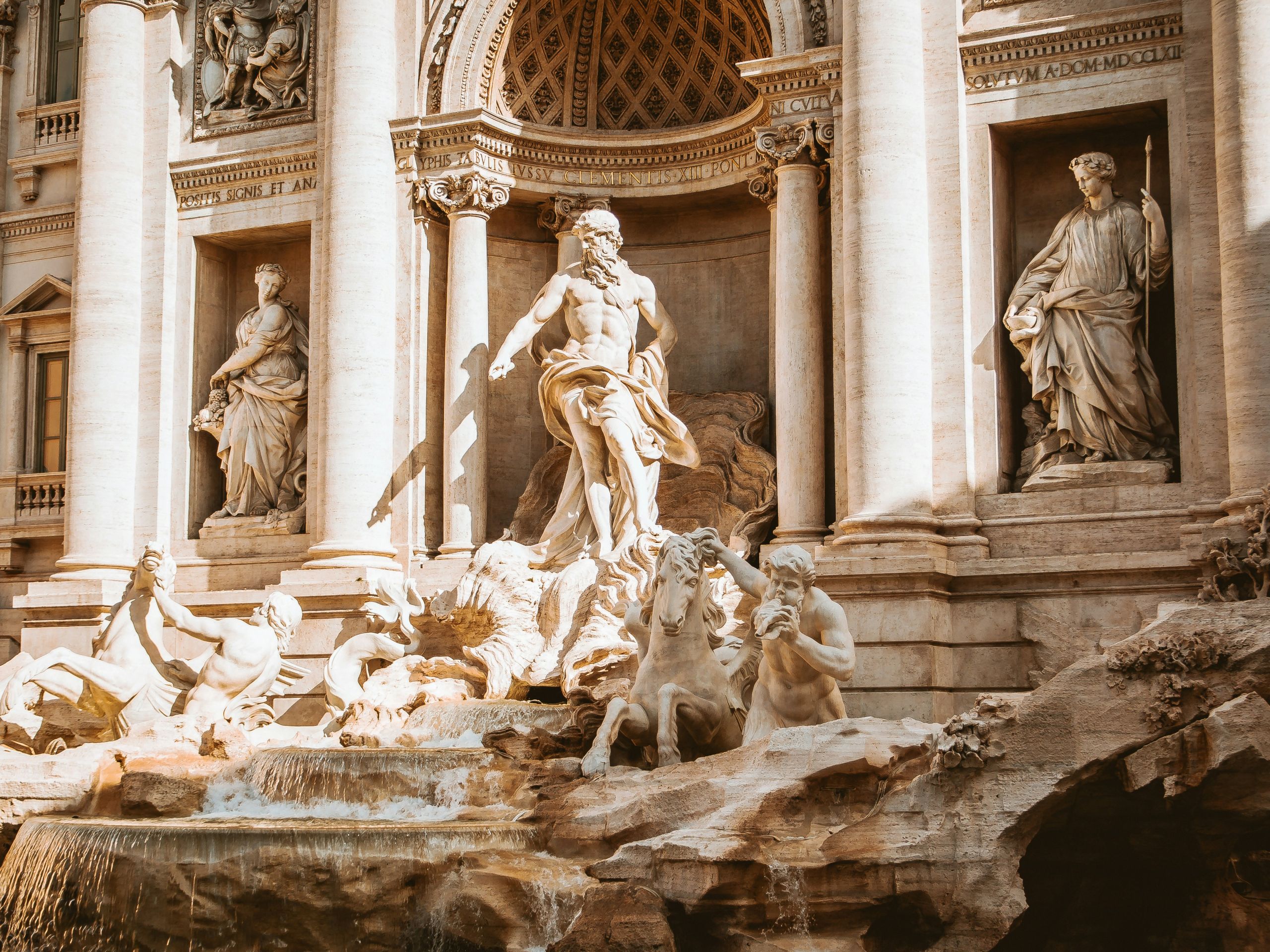 Two statues of men, two wome, and a horse built into a roman building in Rome