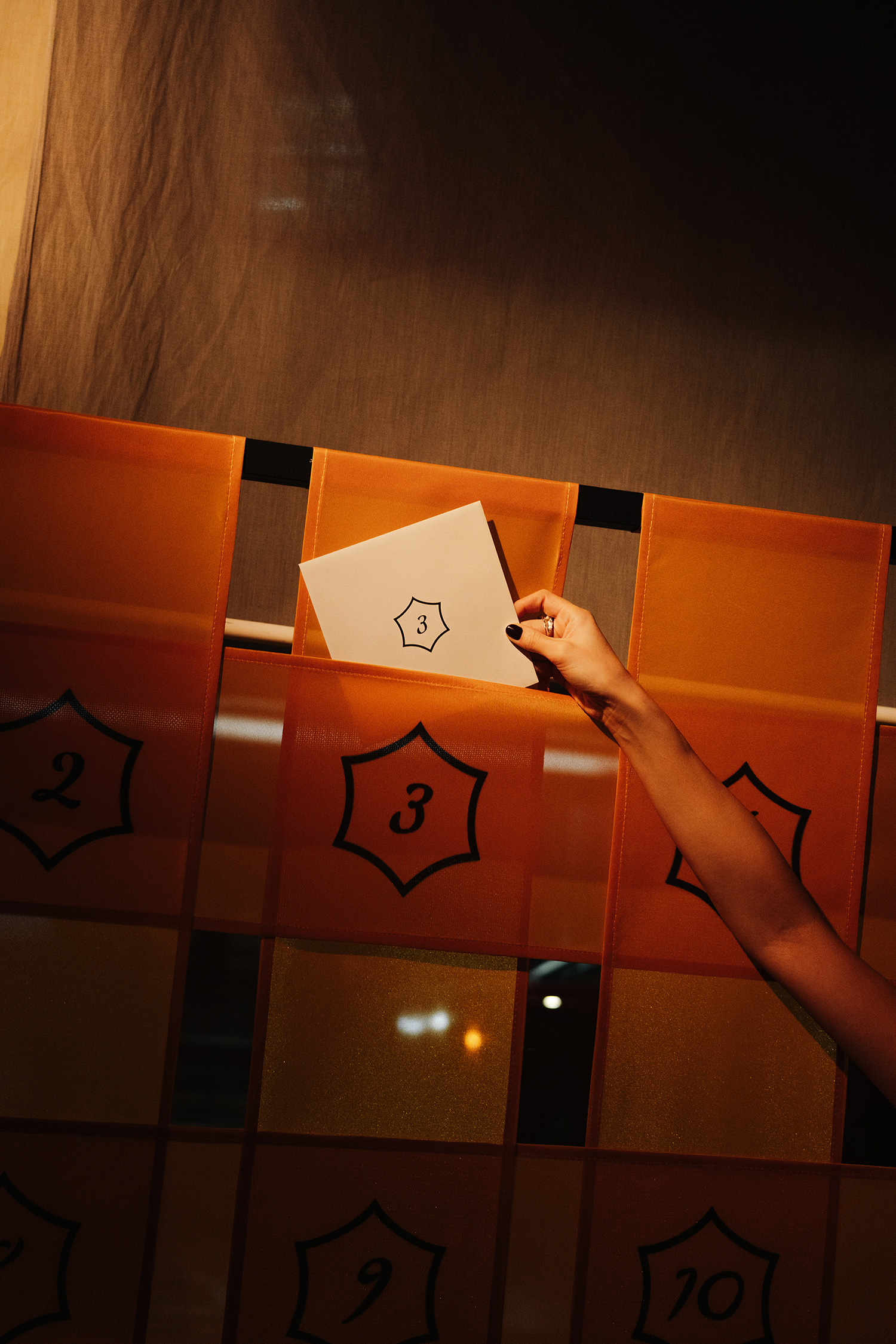 Someone holds a sheet of paper against an orange file holder