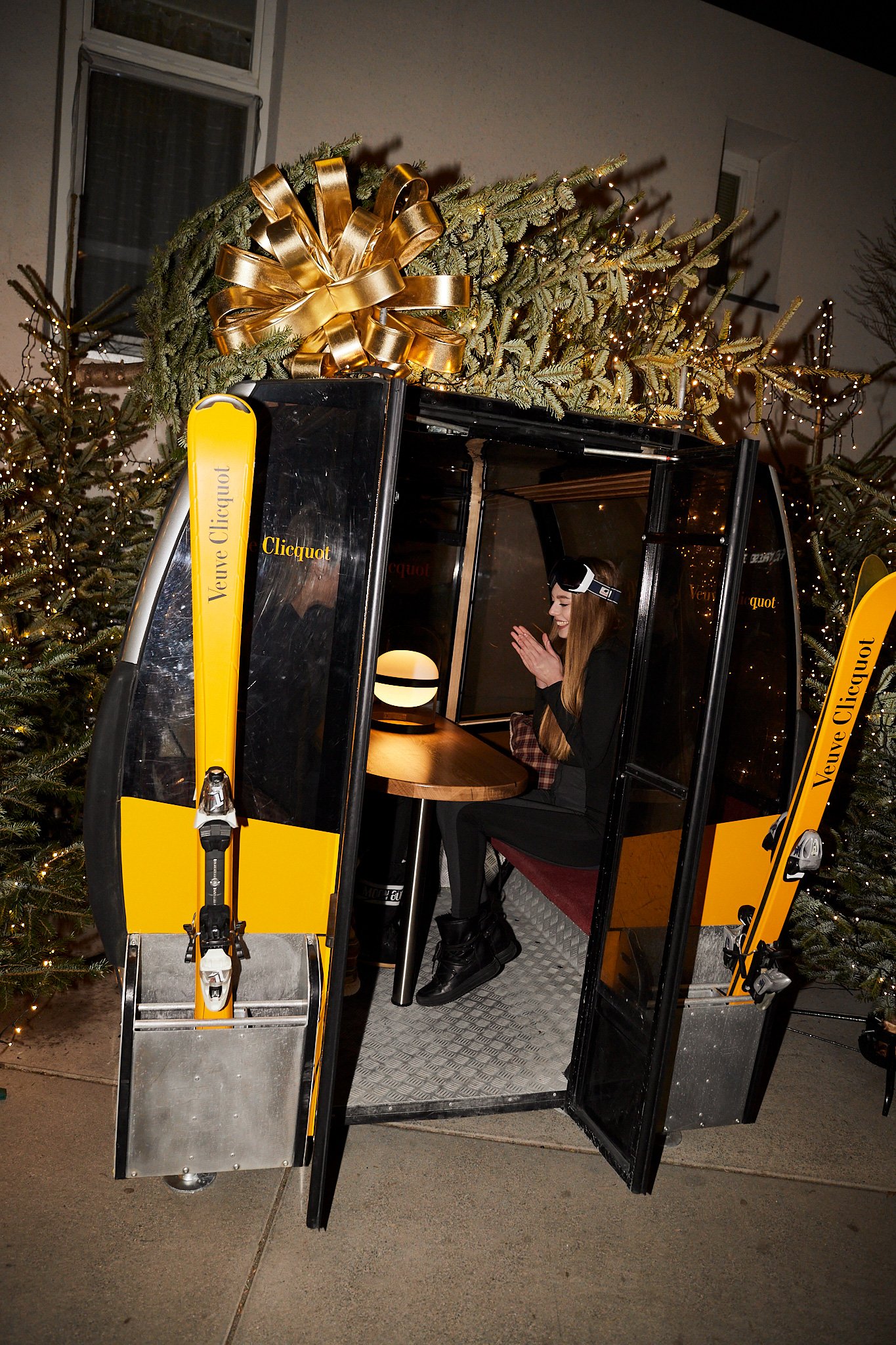 A woman enjoying a scenic view from a ski lift, with a festive Christmas tree in the background.